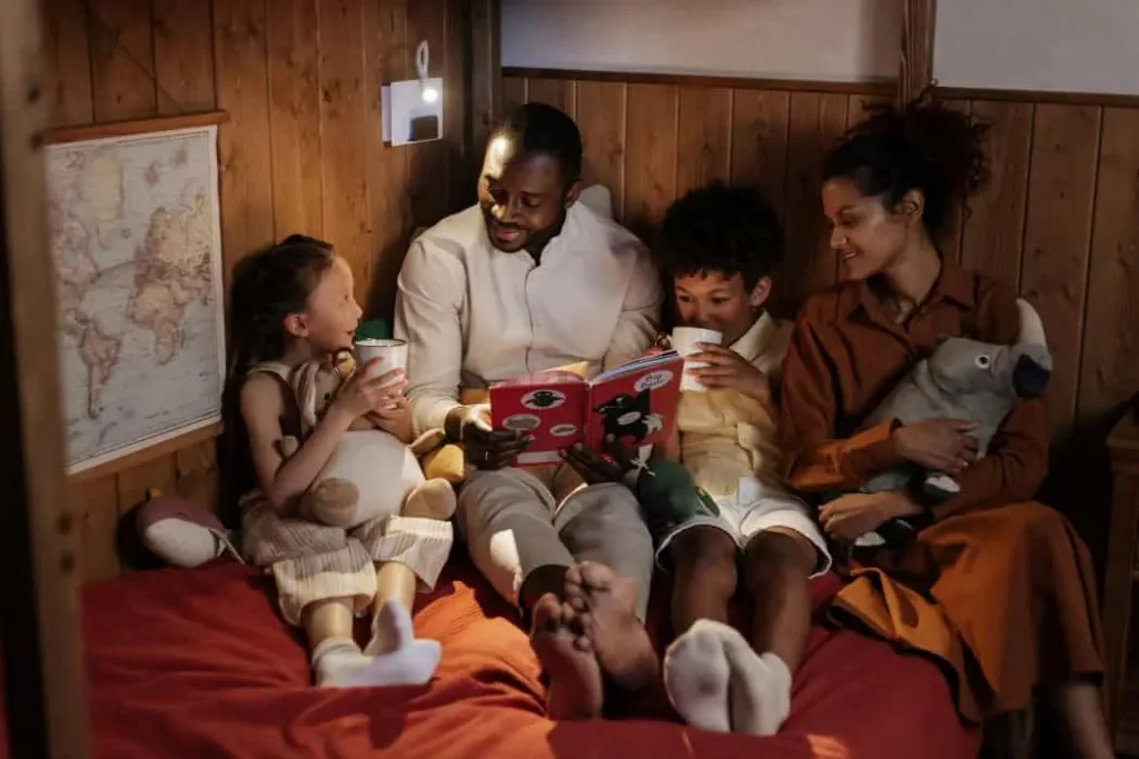 Types of Love (Familial Love) - A family sitting together on a bed which appears cozy and inviting, emphasizing the love and bond within the family